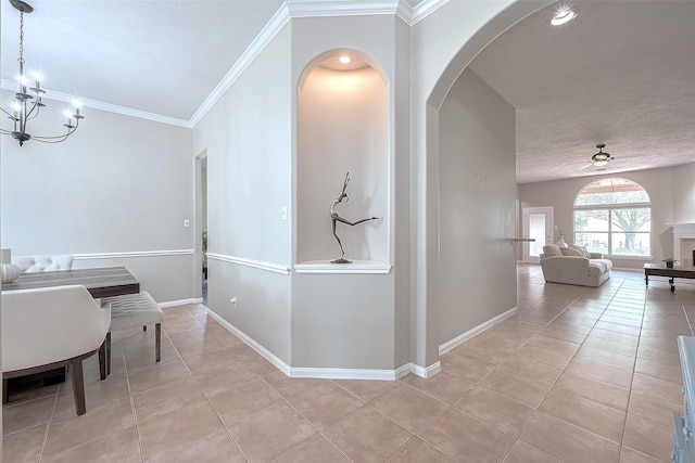 21122 Lilac Meadows Ln, Richmond, TX 77407 - hall with light tile patterned floors, arched walkways, a chandelier, ornamental molding, and baseboards