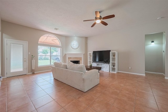 21122 Lilac Meadows Ln, Richmond, TX 77407 - living room featuring ceiling fan, a fireplace, light tile patterned flooring, and baseboards