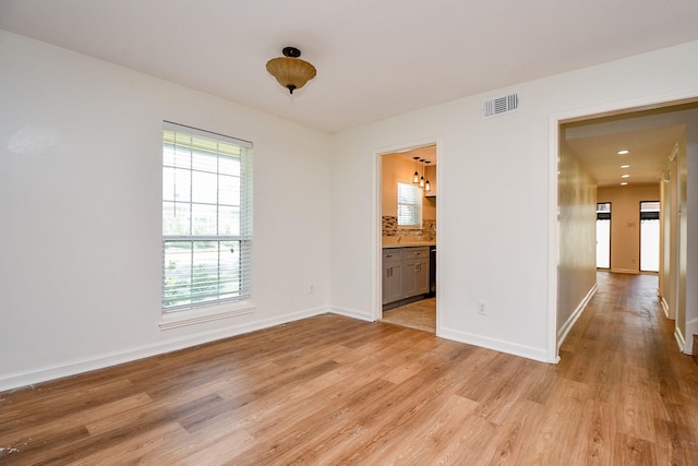 500 N Post Oak Ln, Houston, TX 77024 - unfurnished room featuring light wood-style floors, healthy amount of natural light, baseboards, and a chandelier