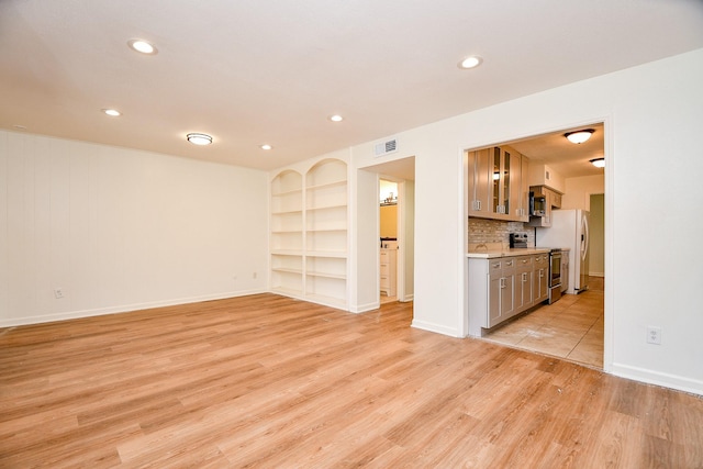 500 N Post Oak Ln, Houston, TX 77024 - unfurnished living room featuring light wood-type flooring, recessed lighting, baseboards, and built in features