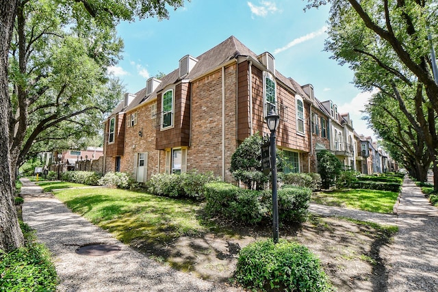 500 N Post Oak Ln, Houston, TX 77024 - view of property exterior with a residential view, brick siding, and a yard