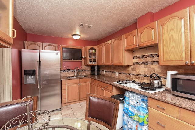 130 Ben Dr, Houston, TX 77022 - kitchen featuring stainless steel appliances, a sink, backsplash, dark stone countertops, and glass insert cabinets