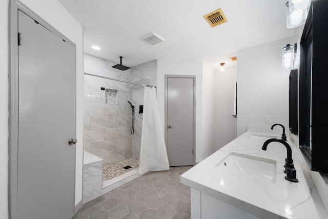22338 Prince George St, Katy, TX 77449 - bathroom featuring a tile shower, double vanity, a textured ceiling, recessed lighting, and tile patterned floors