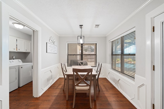 22338 Prince George St, Katy, TX 77449 - dining room with washing machine and clothes dryer, a decorative wall, dark wood-type flooring, crown molding, and a wainscoted wall