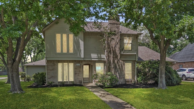 22338 Prince George St, Katy, TX 77449 - view of front of house featuring a front lawn, a chimney, a shingled roof, and brick siding