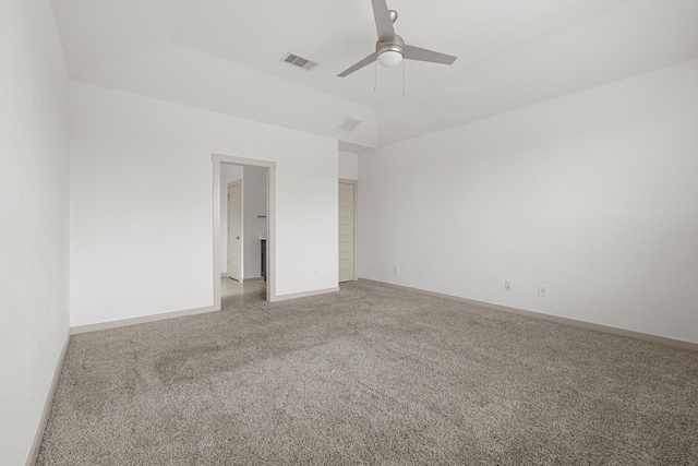 spare room with light colored carpet, a ceiling fan, and baseboards