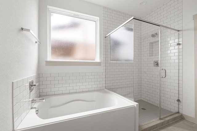 full bathroom featuring a shower stall and a bath