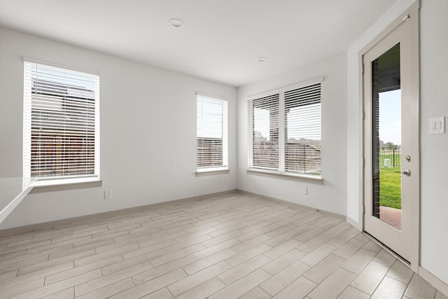 unfurnished room with baseboards and light wood-style flooring