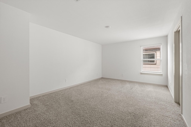 carpeted empty room with baseboards