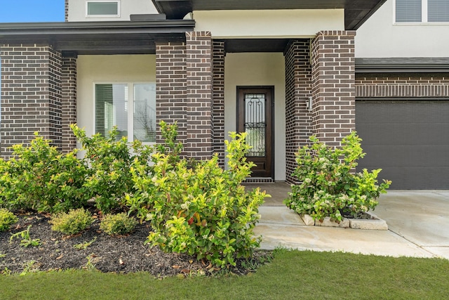 doorway to property featuring brick siding and stucco siding