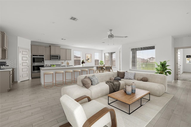 living room featuring ceiling fan, light wood-style flooring, and recessed lighting