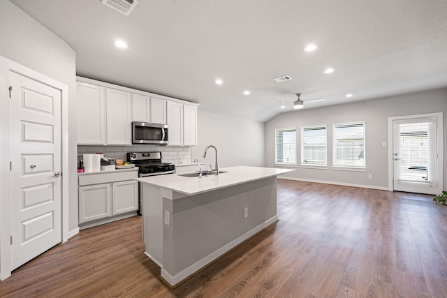 7438 Victoria Brook Trce, Richmond, TX 77407 - kitchen featuring appliances with stainless steel finishes, a sink, ceiling fan, backsplash, and wood finished floors