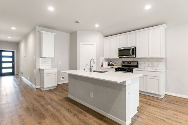 7438 Victoria Brook Trce, Richmond, TX 77407 - kitchen with appliances with stainless steel finishes, a sink, tasteful backsplash, recessed lighting, and light wood-style floors