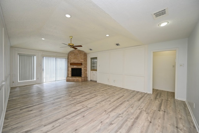 7735 Quail Meadow Dr, Houston, TX 77071 - unfurnished living room featuring a ceiling fan, a brick fireplace, light wood-type flooring, lofted ceiling, and a decorative wall