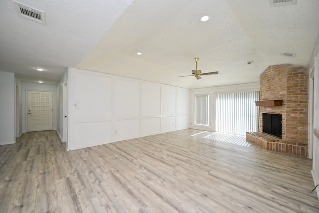 7735 Quail Meadow Dr, Houston, TX 77071 - unfurnished living room featuring a decorative wall, a textured ceiling, light wood-style flooring, ceiling fan, and a fireplace