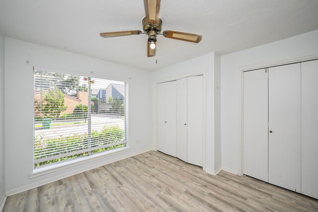 7735 Quail Meadow Dr, Houston, TX 77071 - unfurnished bedroom with light wood finished floors, multiple closets, and a ceiling fan