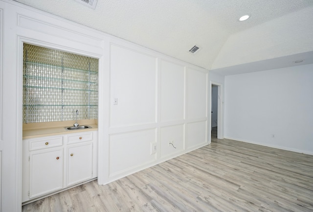 7735 Quail Meadow Dr, Houston, TX 77071 - unfurnished room featuring light wood-style flooring, recessed lighting, wet bar, and vaulted ceiling