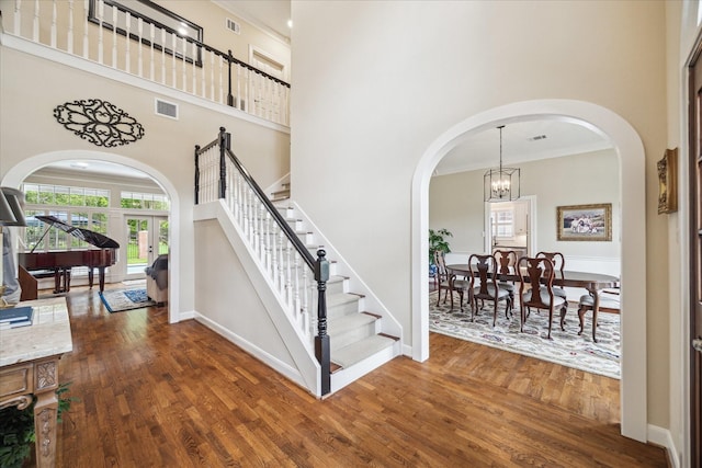 51 Dartmoor Ct, Sugar Land, TX 77479 - stairs with a high ceiling, arched walkways, wood finished floors, a chandelier, and crown molding