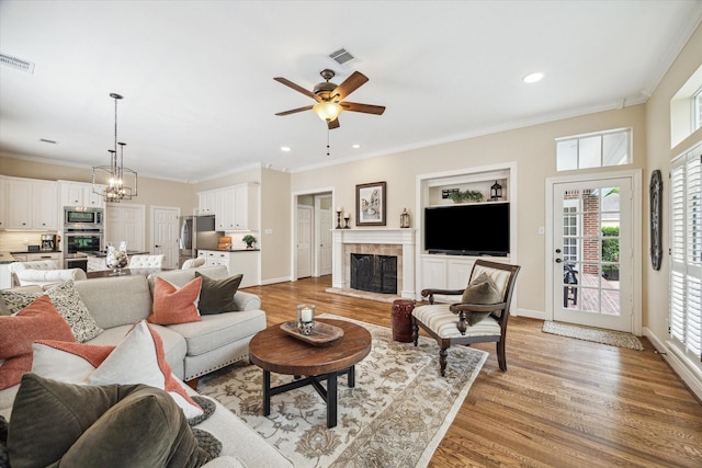 51 Dartmoor Ct, Sugar Land, TX 77479 - living area featuring a ceiling fan, a chandelier, light wood-type flooring, plenty of natural light, and crown molding