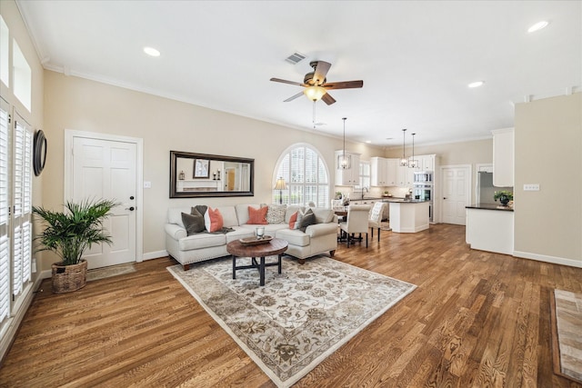 51 Dartmoor Ct, Sugar Land, TX 77479 - living area featuring ceiling fan, wood finished floors, ornamental molding, recessed lighting, and baseboards