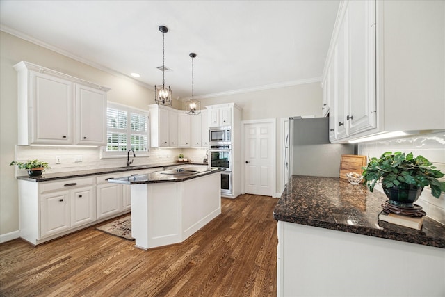 51 Dartmoor Ct, Sugar Land, TX 77479 - kitchen with a sink, appliances with stainless steel finishes, white cabinetry, backsplash, and ornamental molding