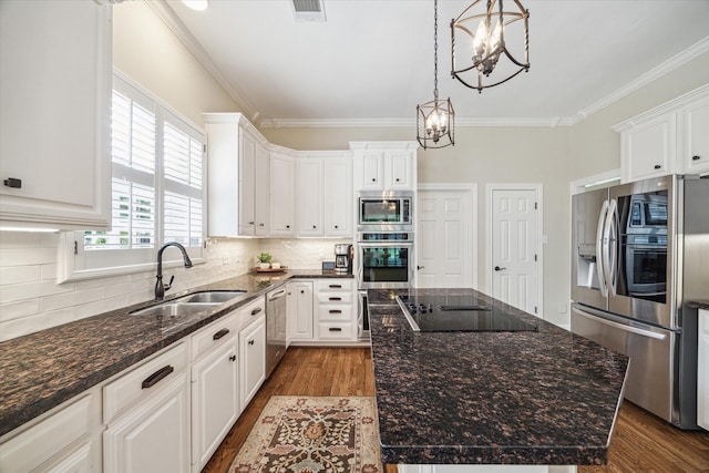 51 Dartmoor Ct, Sugar Land, TX 77479 - kitchen with appliances with stainless steel finishes, a sink, a chandelier, dark wood-type flooring, and ornamental molding