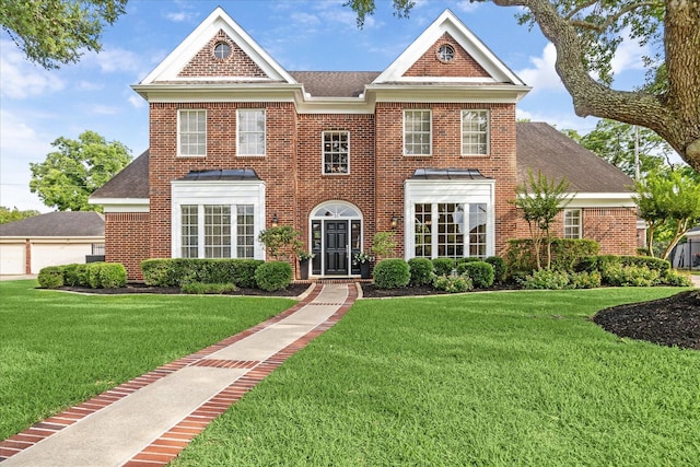 51 Dartmoor Ct, Sugar Land, TX 77479 - georgian-style home featuring brick siding, a front yard, a detached garage, and roof with shingles