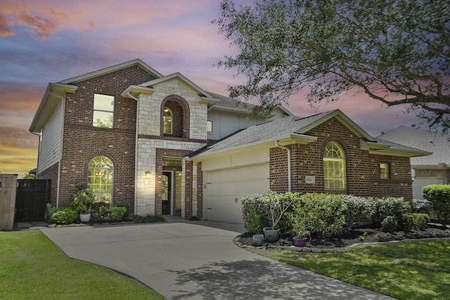 view of front facade with a garage, driveway, brick siding, and stone siding