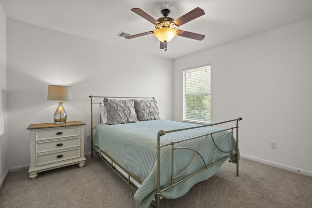bedroom with light colored carpet, baseboards, and a ceiling fan