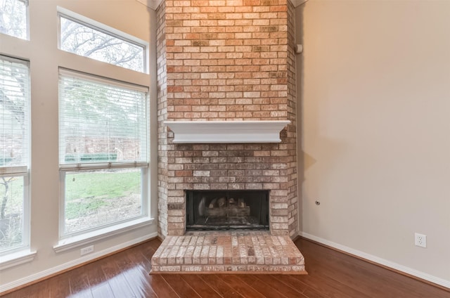 12950 Quail Park Dr, Cypress, TX 77429 - unfurnished living room with wood finished floors, baseboards, and a brick fireplace