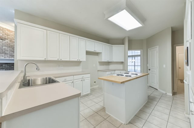 12950 Quail Park Dr, Cypress, TX 77429 - kitchen with a sink, light tile patterned flooring, white cabinets, wood counters, and a kitchen island
