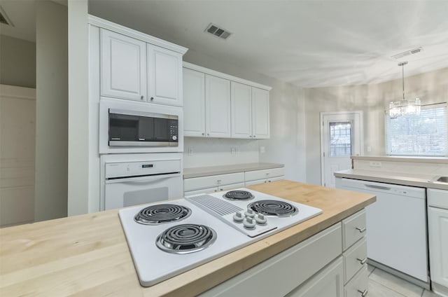 12950 Quail Park Dr, Cypress, TX 77429 - kitchen with white appliances, white cabinetry, butcher block countertops, hanging light fixtures, and a chandelier