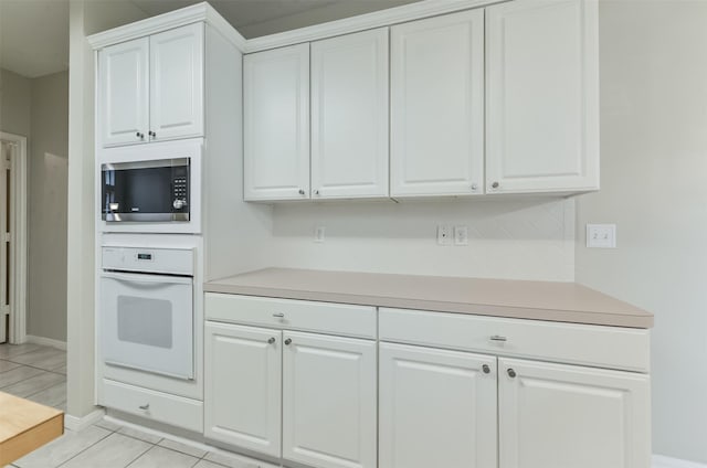 12950 Quail Park Dr, Cypress, TX 77429 - kitchen featuring white oven, stainless steel microwave, light countertops, and white cabinetry