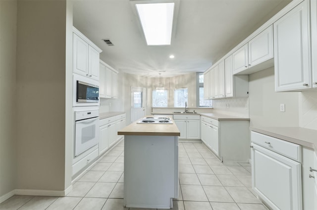 12950 Quail Park Dr, Cypress, TX 77429 - kitchen featuring white appliances, a sink, light countertops, white cabinets, and recessed lighting