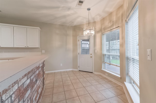 12950 Quail Park Dr, Cypress, TX 77429 - unfurnished dining area with a chandelier, light tile patterned floors, and baseboards