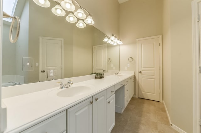 12950 Quail Park Dr, Cypress, TX 77429 - bathroom featuring a high ceiling, double vanity, tile patterned floors, and baseboards