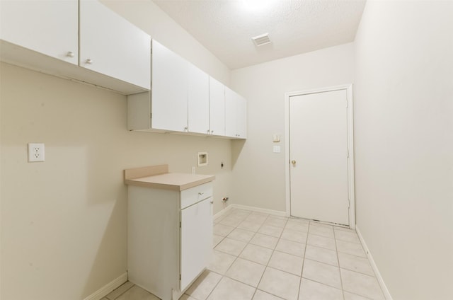 12950 Quail Park Dr, Cypress, TX 77429 - washroom with washer hookup, cabinet space, electric dryer hookup, light tile patterned floors, and a textured ceiling