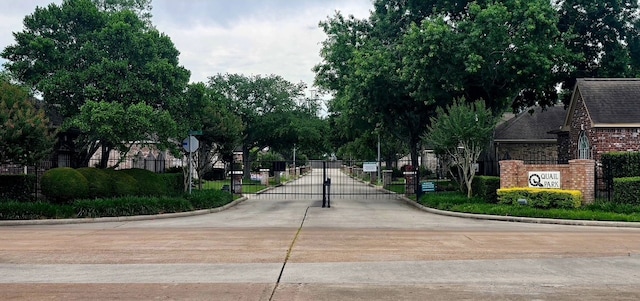 12950 Quail Park Dr, Cypress, TX 77429 - view of concrete street featuring a gate, curbs, a gated entry, and traffic signs