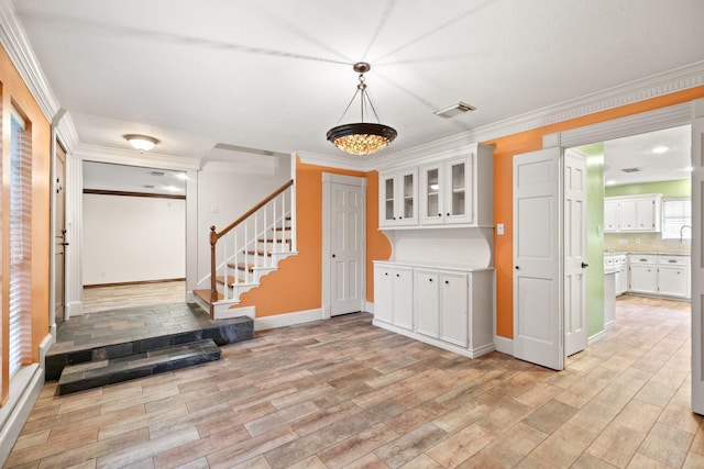 12923 Hunterfield Dr, Cypress, TX 77429 - kitchen featuring white cabinets, light wood finished floors, ornamental molding, baseboards, and light countertops