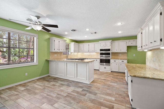 12923 Hunterfield Dr, Cypress, TX 77429 - kitchen with a peninsula, tasteful backsplash, white cabinetry, recessed lighting, and a textured ceiling