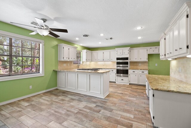 12923 Hunterfield Dr, Cypress, TX 77429 - kitchen featuring stainless steel appliances, a peninsula, backsplash, white cabinetry, and recessed lighting