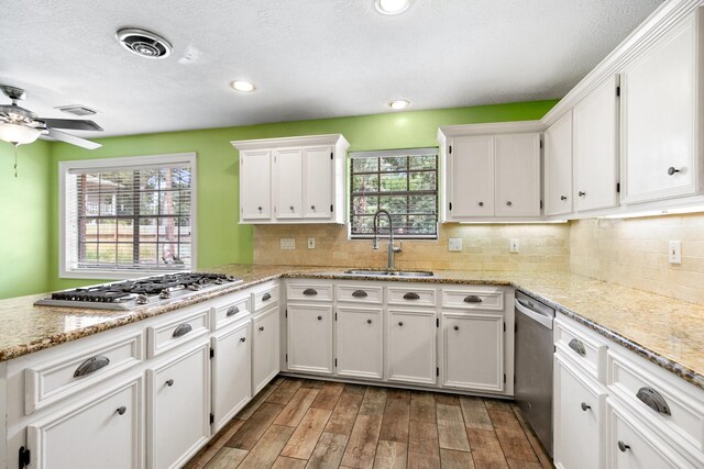 12923 Hunterfield Dr, Cypress, TX 77429 - kitchen with appliances with stainless steel finishes, a sink, white cabinetry, wood finished floors, and ceiling fan