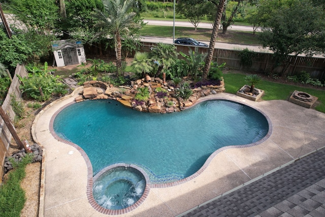 12923 Hunterfield Dr, Cypress, TX 77429 - view of swimming pool with a shed, a fenced backyard, an outdoor structure, a pool with connected hot tub, and a patio