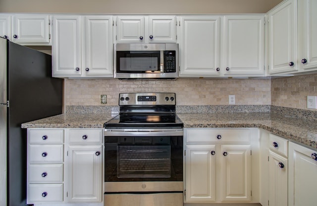 2111 Welch St Unit A110, Houston, TX 77019 - kitchen with appliances with stainless steel finishes, white cabinets, light stone countertops, and decorative backsplash