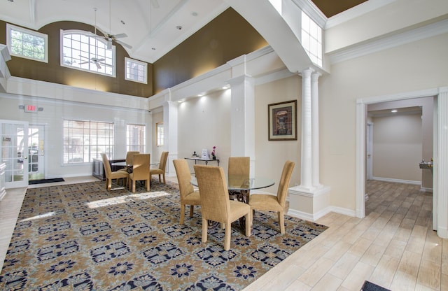 2111 Welch St Unit A110, Houston, TX 77019 - dining room featuring decorative columns, a towering ceiling, ceiling fan, light wood finished floors, and healthy amount of natural light