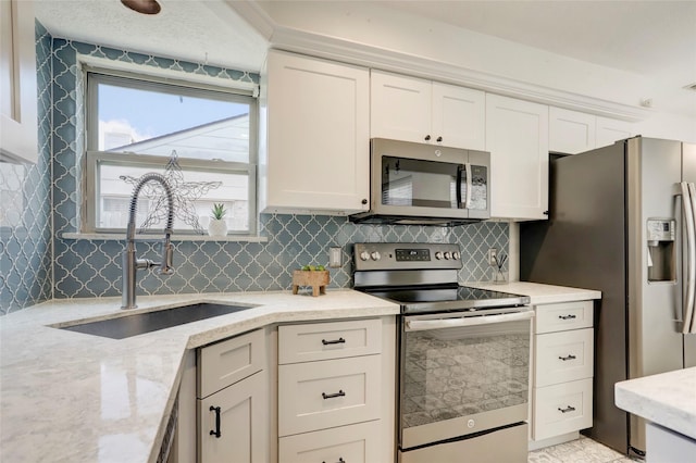 6202 Arcadian Shores Dr, Houston, TX 77084 - kitchen featuring appliances with stainless steel finishes, a sink, tasteful backsplash, and white cabinetry
