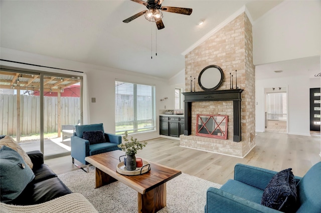 6202 Arcadian Shores Dr, Houston, TX 77084 - living room featuring a ceiling fan, high vaulted ceiling, light wood finished floors, a fireplace, and crown molding