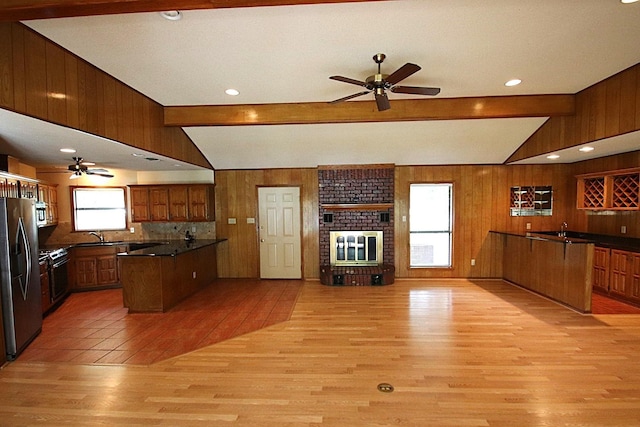 606 County Road 1947, Yantis, TX 75497 - kitchen featuring stainless steel refrigerator with ice dispenser, a ceiling fan, a peninsula, wooden walls, and open floor plan