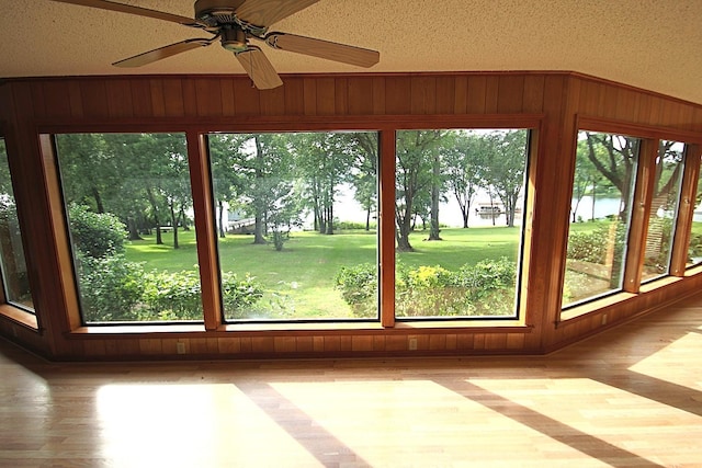 606 County Road 1947, Yantis, TX 75497 - unfurnished sunroom featuring wooden walls, wood finished floors, and a textured ceiling