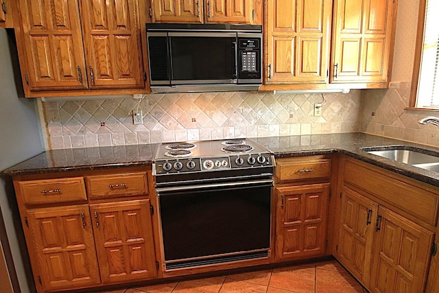 606 County Road 1947, Yantis, TX 75497 - kitchen featuring electric range, a sink, brown cabinets, dark stone counters, and decorative backsplash